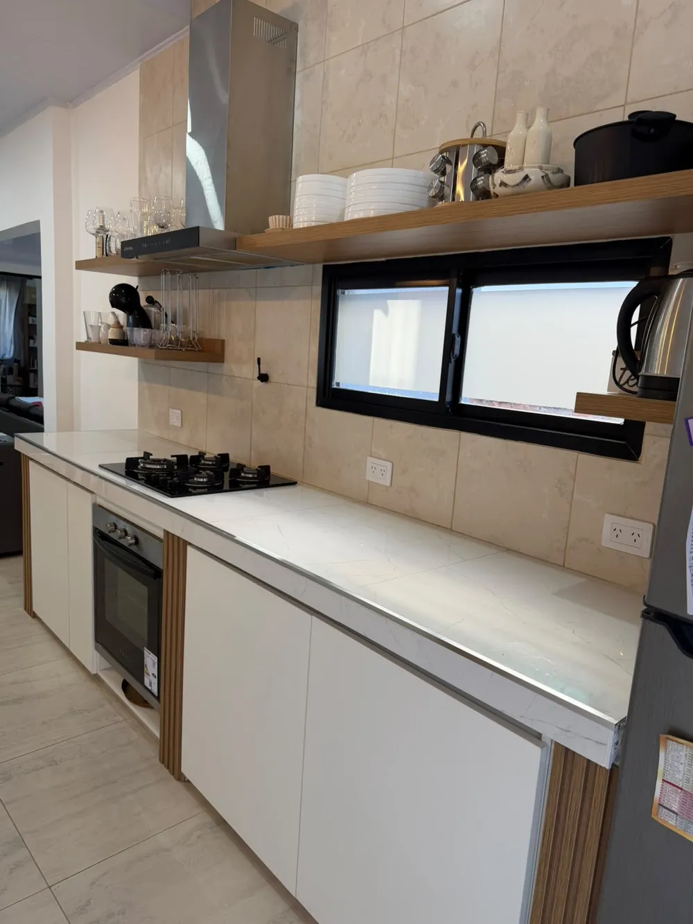 La misma cocina: estantes flotantes de madera sobre la mesada