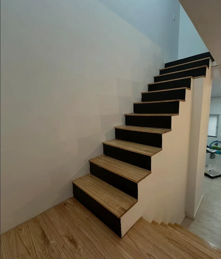 Escalera con huellas de madera maciza y contrahuellas negras